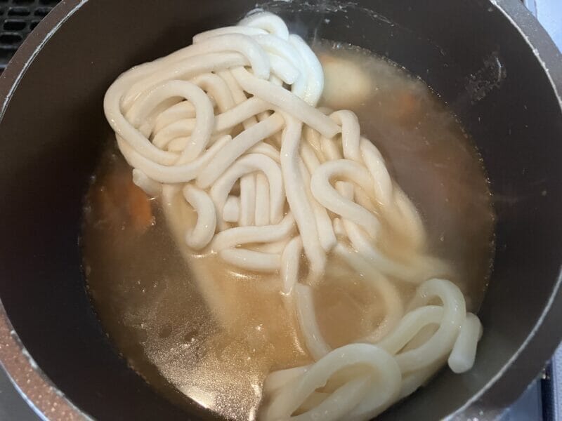 鍋に入れた冷凍讃岐うどんと中華丼のもと